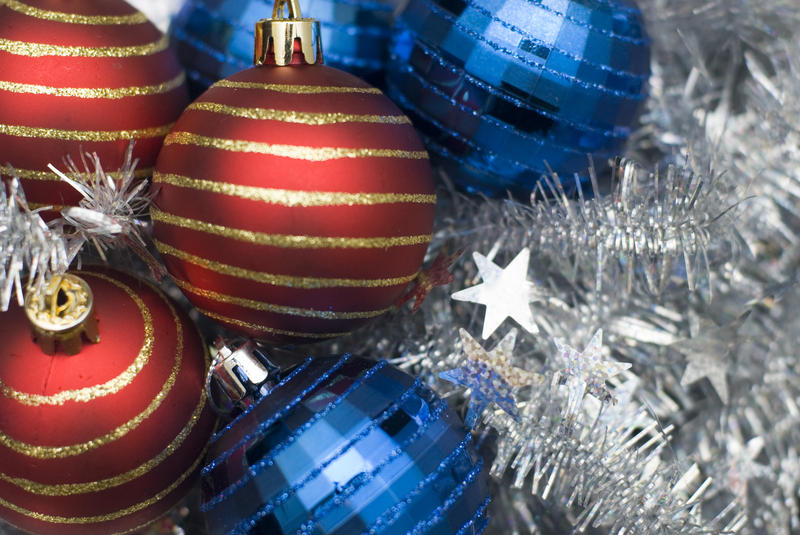 an assortment of reflective christmas baubles on a background of silver tinsel