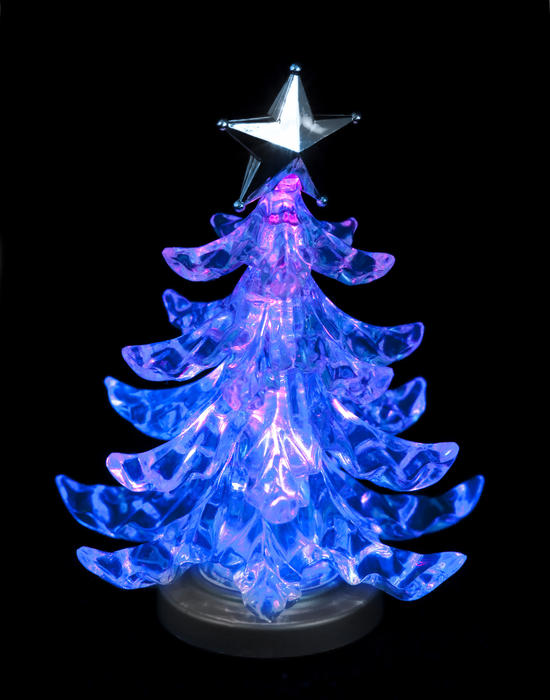 a glowing christmas tree shaped light on a black backdrop