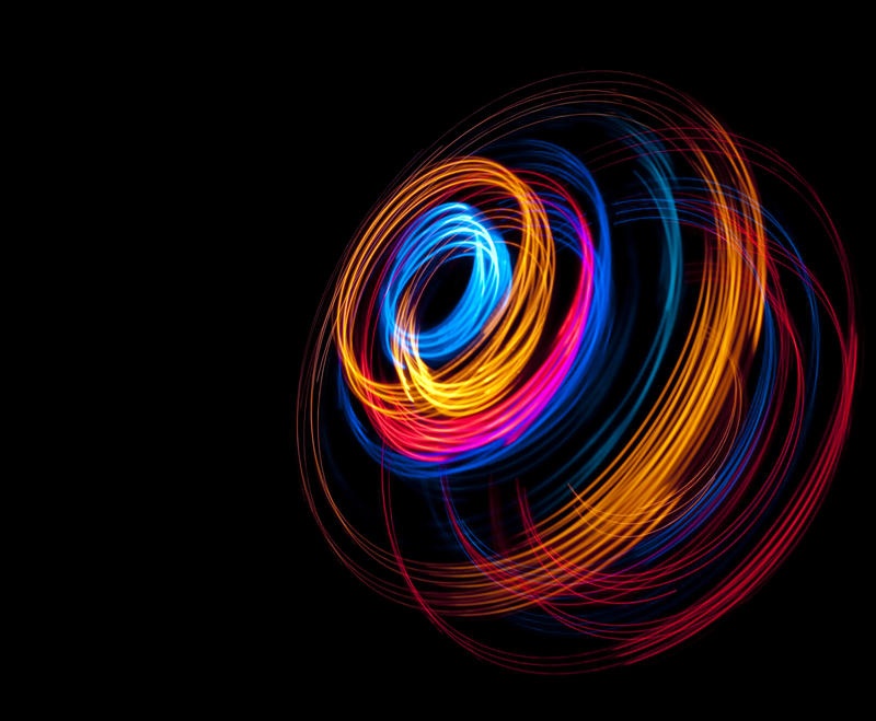 a dramatic colorful image composed of light painting effects on a black backdrop