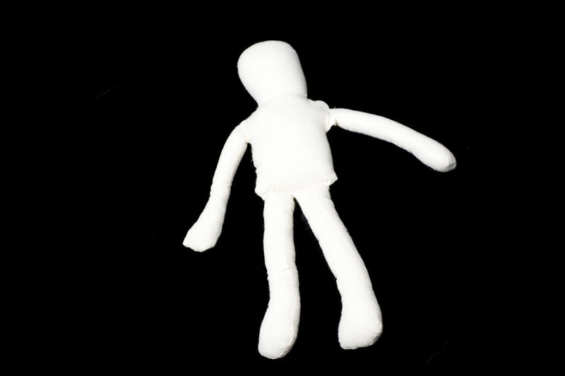 a cloth rag doll on a black background