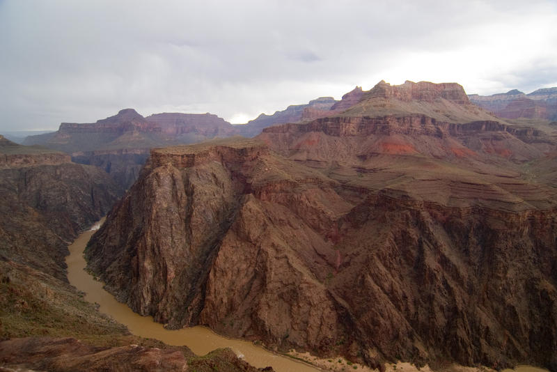 rugged mountain landscape frames a photo of a bend in the colorado river