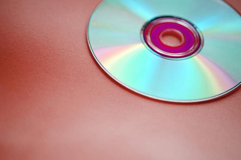 a cross processed image of a DVD disk on a red background