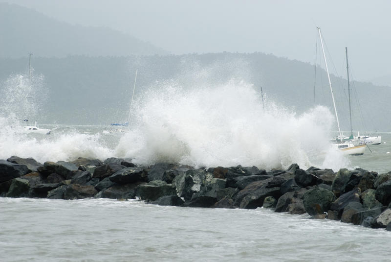 heavy seas and waves washing over sea defences during a tropical storm