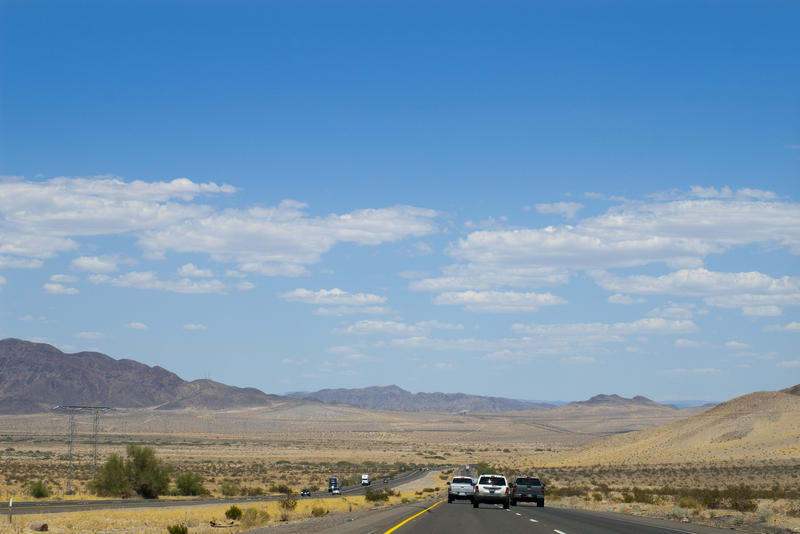 cars driving along a freeway in the california desert