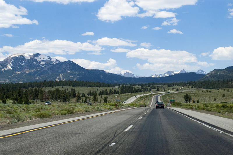 driving through the california high country, snow capped mountain ranges make impressive scenery