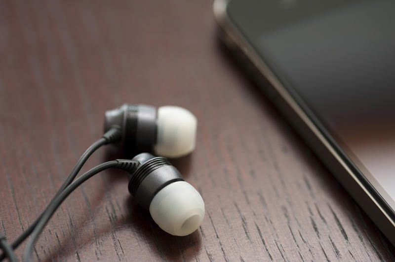 a pair of headpones conected to a mobile phone for listening to mp3s