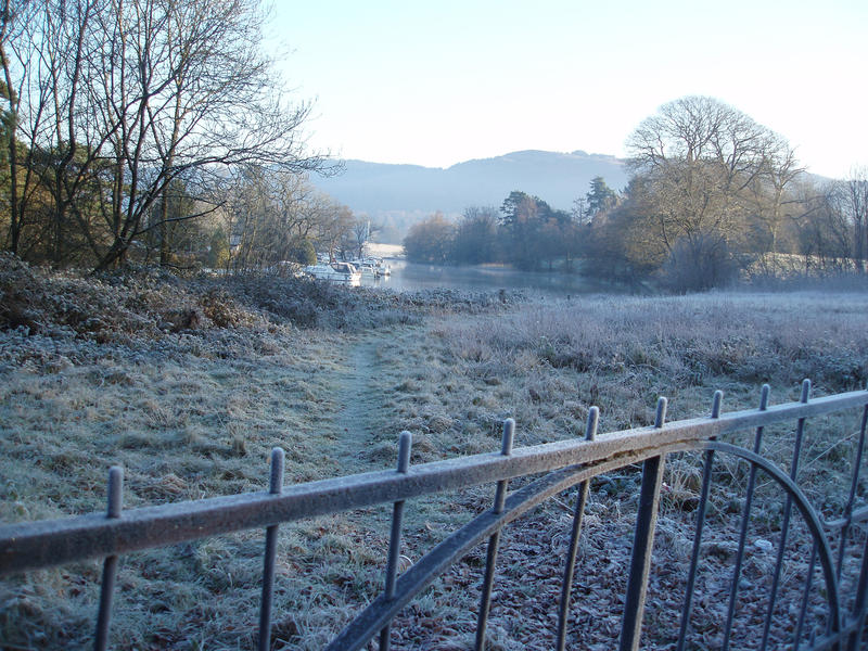 a view looking out over a meadow at the end of lake windermere of a cold and frosty morning