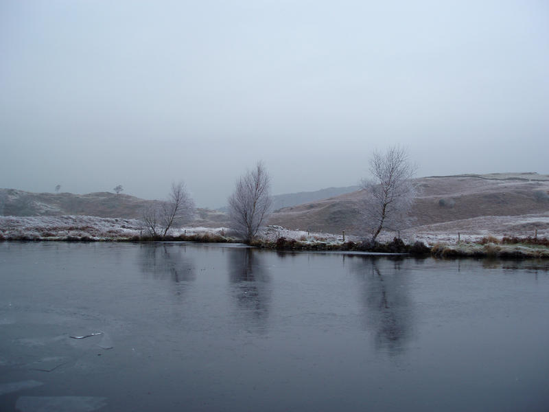 a sheet of ice covering a small tarn in sub zero temperatures