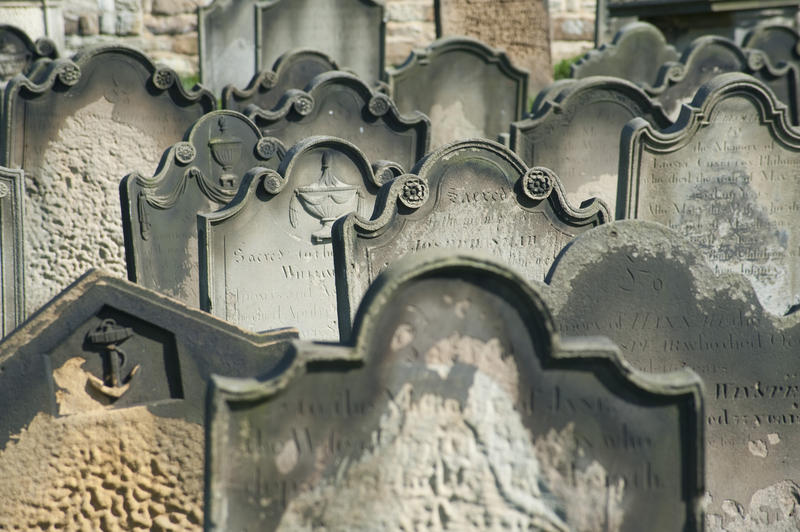 rows of old headstones or gravestones in a cemetery