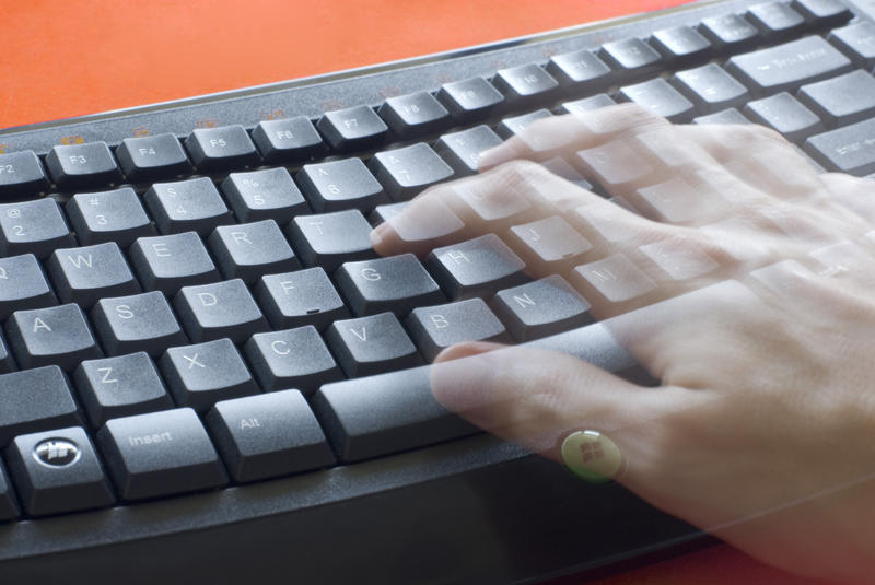 a concept image of a keyboard and a user with motion blurred hands