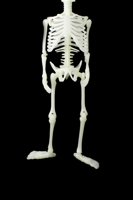skeleton with legs hanging in the air, isolated on a black background
