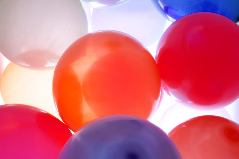 a background image of red and purple colored balloons lit from the back