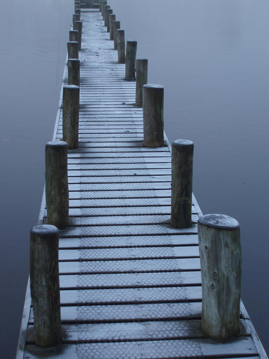 a small wooden jetty on a calm still lake