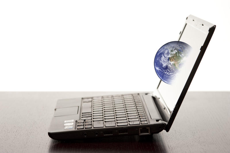 a netbook computer with an earth emerging from the display, concept of the world wide web and internet