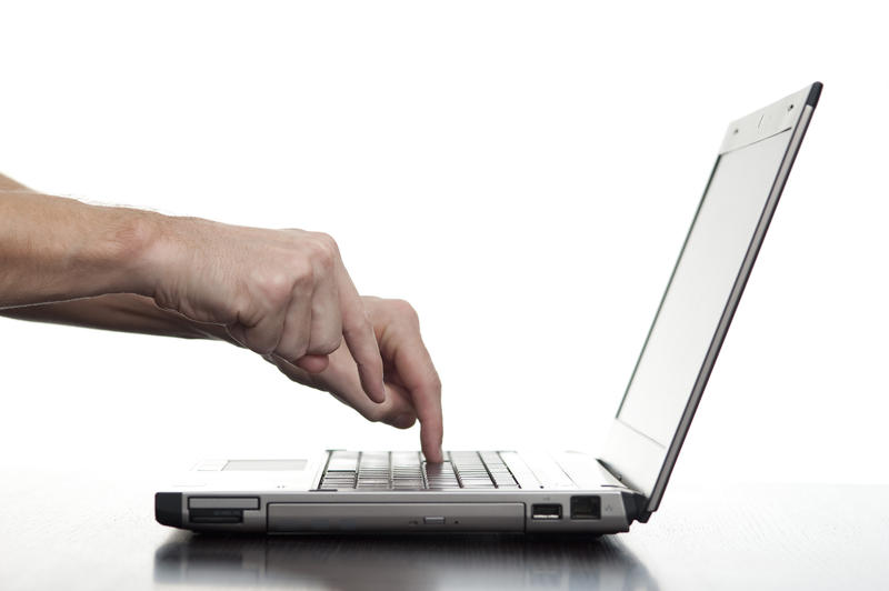 hands pecking at keys on a laptop keyboard, concept learning to type