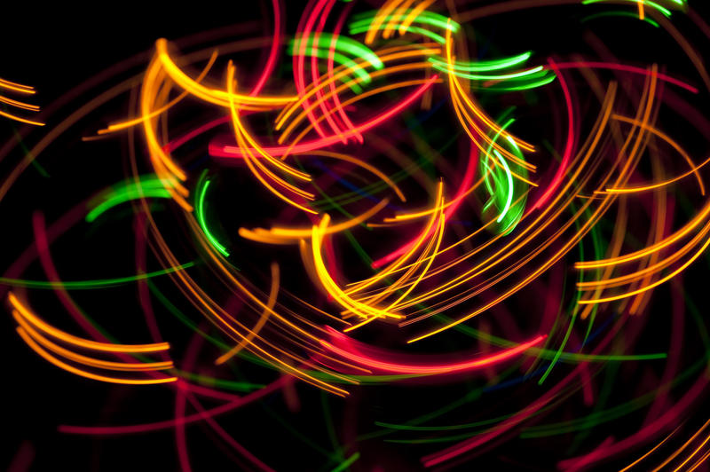 randomly overlapping orange, red and green arcs of light