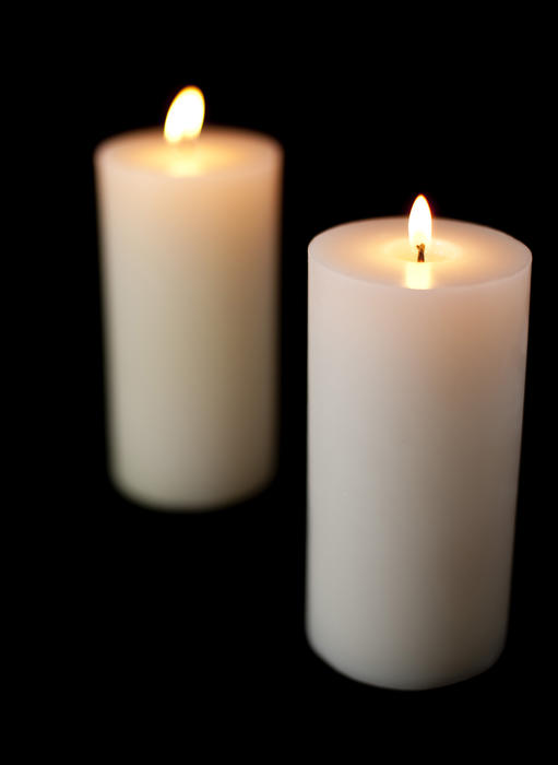 two lit christmas candles on a black background