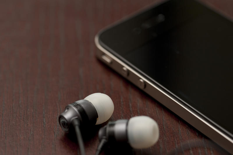 a mobile phone and a pair of headphones laid on table