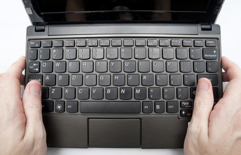 two hands holding a netbook computer