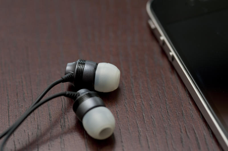 a pair of in ear headphones connected to a mobile phone for listening to music