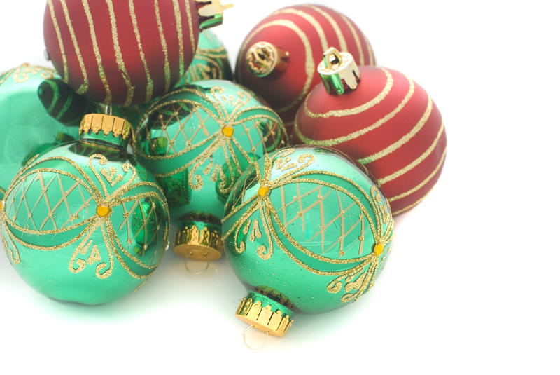 a pile of green and red christmas ball ornaments on a white background