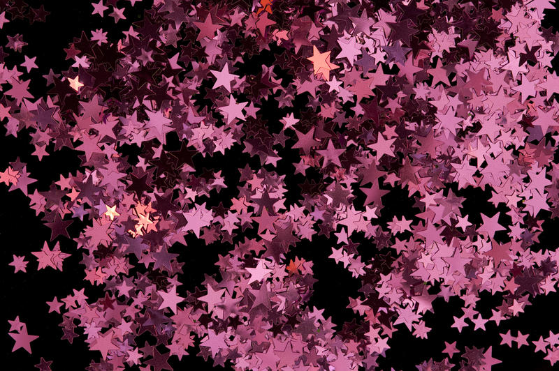 a colorful backdrop of scattered red star shaped confetti