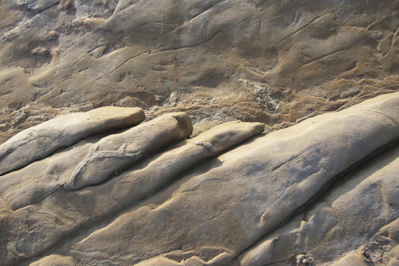 light falling on a scored and rounded rock face