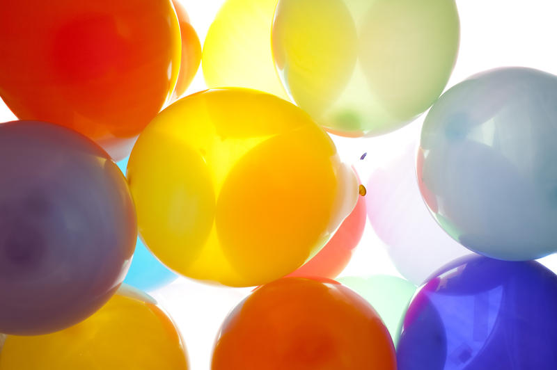 a backlit image of colored balloons