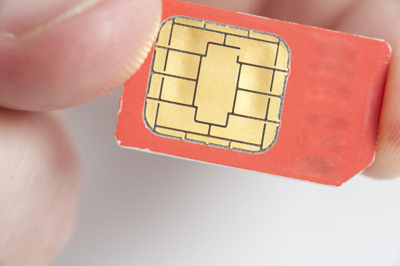 close up on someone holding a mobile phone sim card