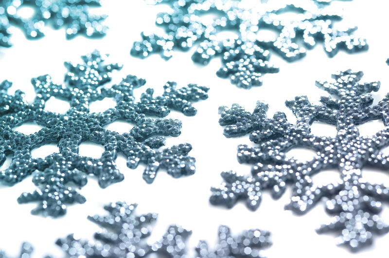 a background image of blue coloured christmas snowflake decorations on a white background