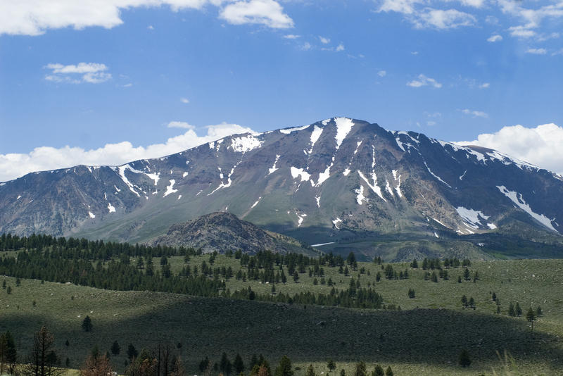 a spring mountain scene, melting snow on the top of a mounain in the sierra navada