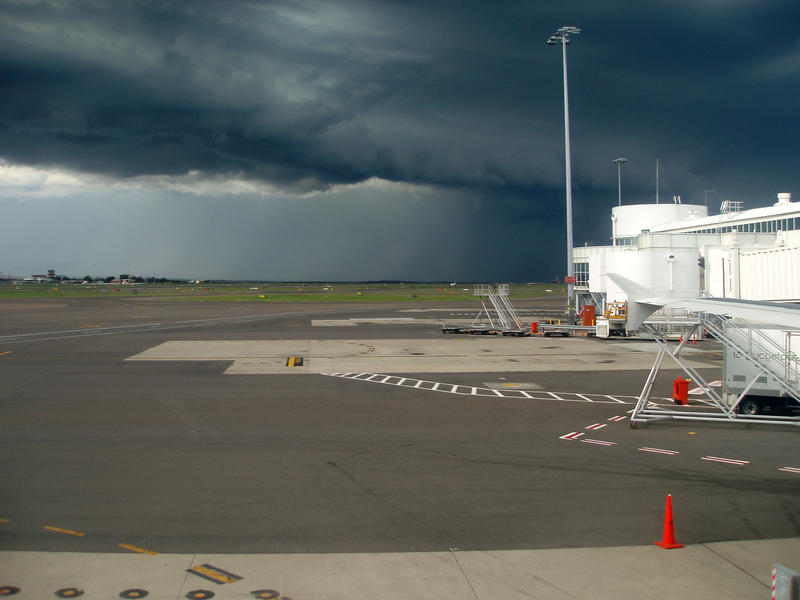 a menacing looking storm cloud over an airport runway