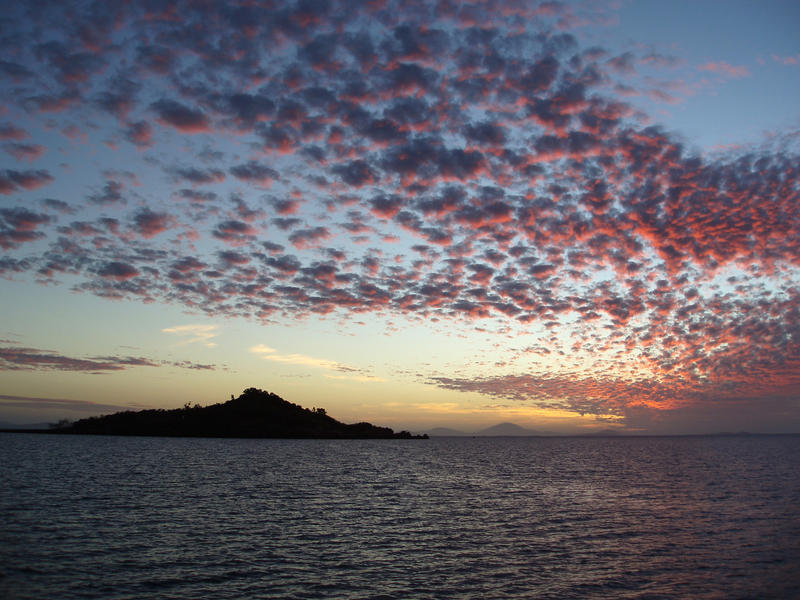 a small island silhouetted against the sunset sky