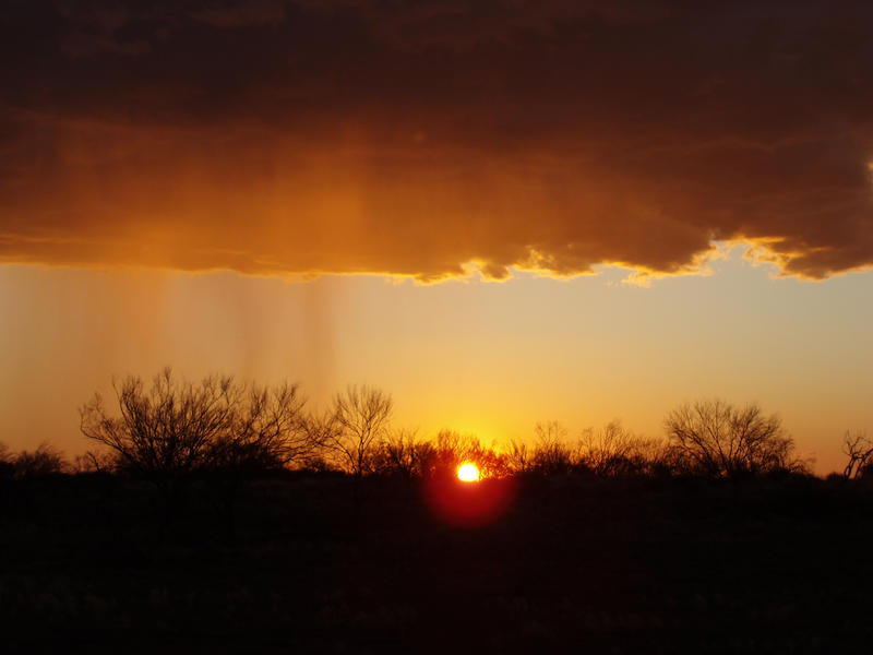 storm clouds breaking over a beautiful orange sunset