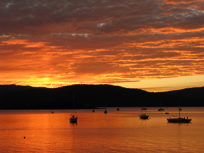 golden glowing sky illuminated yachts on the water at sunset