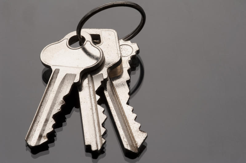 a metal keyring and three keys on a dark surface