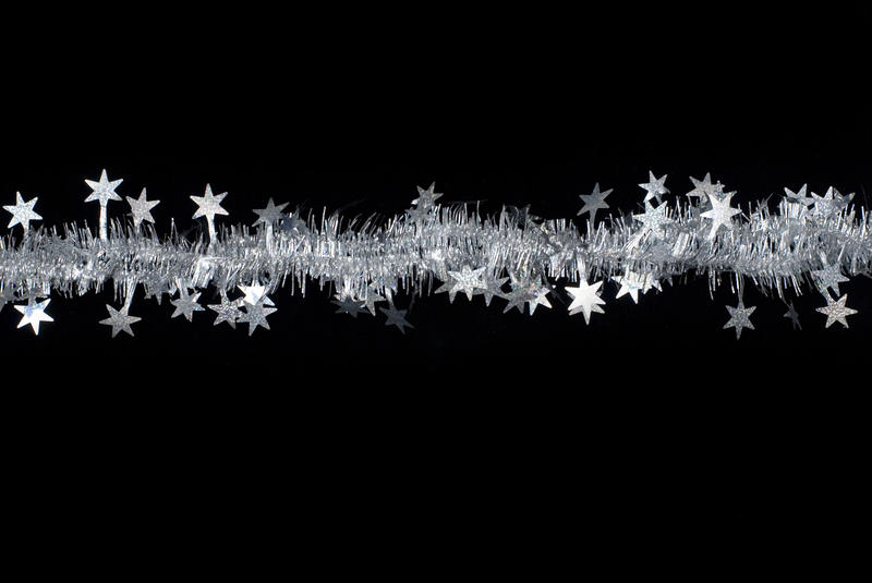 a line of silver tinsel with star shapes on a black background