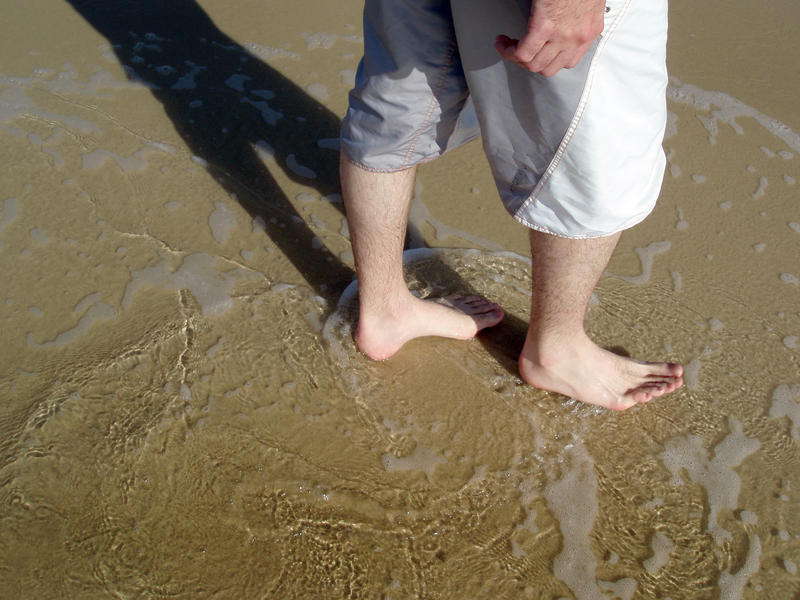 cooling off on a sunny day paddling in shallow water at the beach