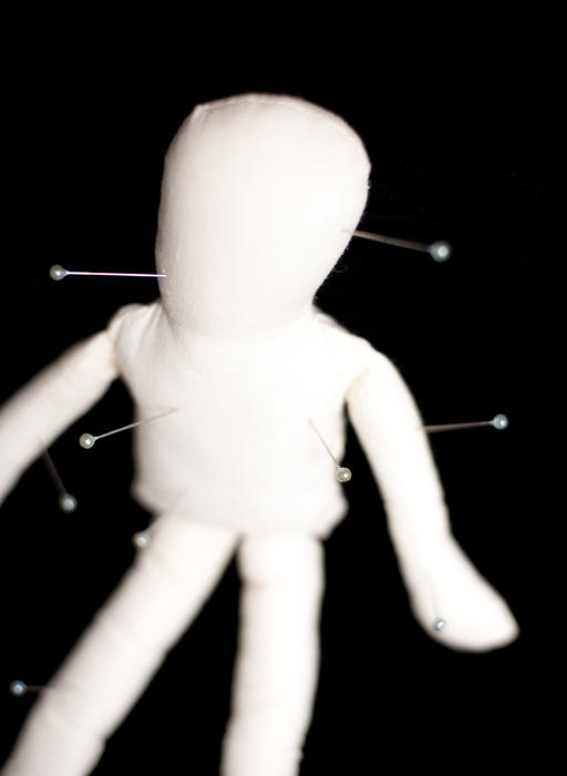 a voodoo doll with needles poked into it