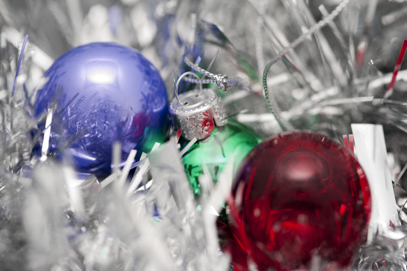 small glass christmas tree baubles on a bed of silver tinsel