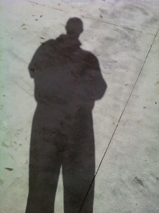<p> Man's shadow on concrete walkway</p>