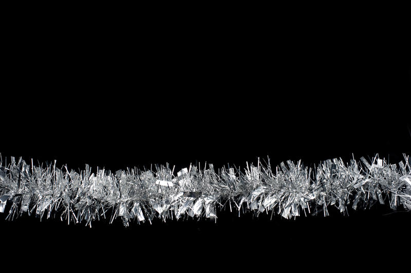 a line of silver christmas tinsel on a plain black background