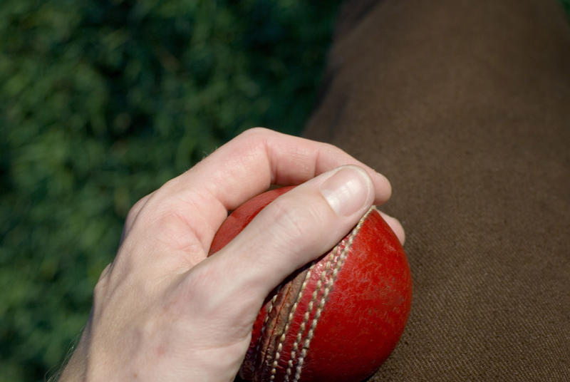polishing a cricket ball to create spin during bowling
