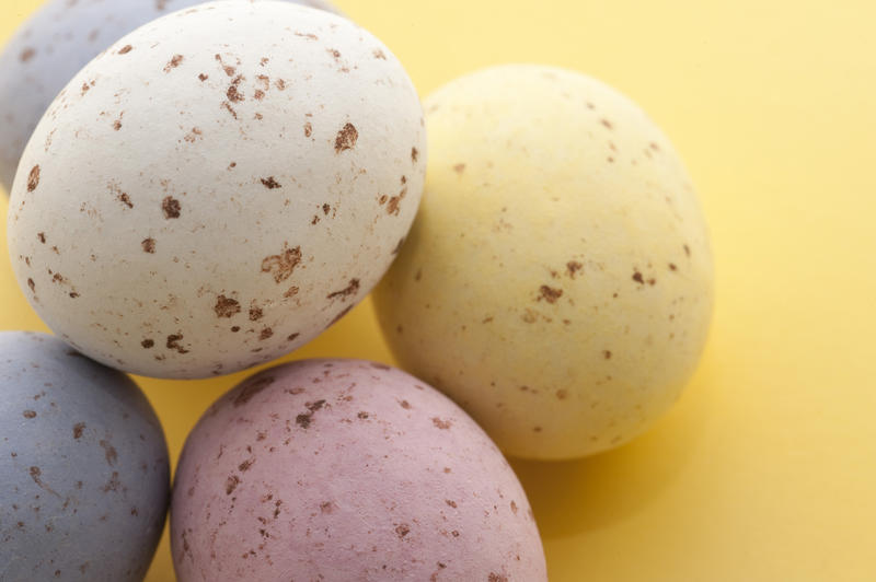 Closeup od pastel coloured speckled Easter Eggs on a yellow background