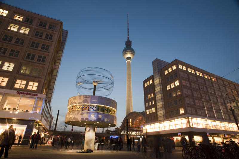 Alexanderplatz, Berlin, at night with lights illuminating the commercial buildings, the World Clock or Weltzeituhr and the Fernsehturm or TV Tower