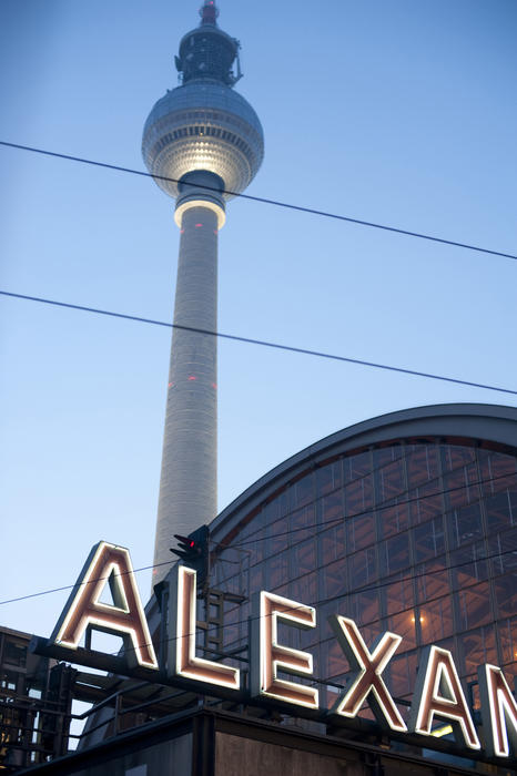 The rooftop Alexanderplatz sign with the domed window of the Bahnhof station and the television tower, or Fernsehturm, behind it