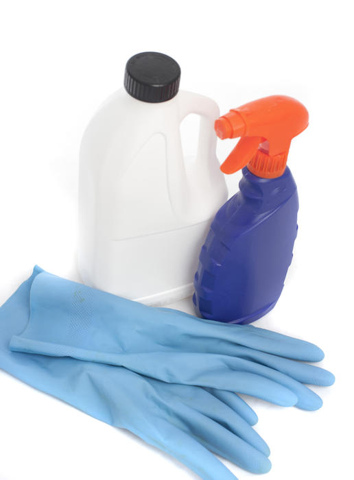 Cleaning products and rubber gloves isolated on white