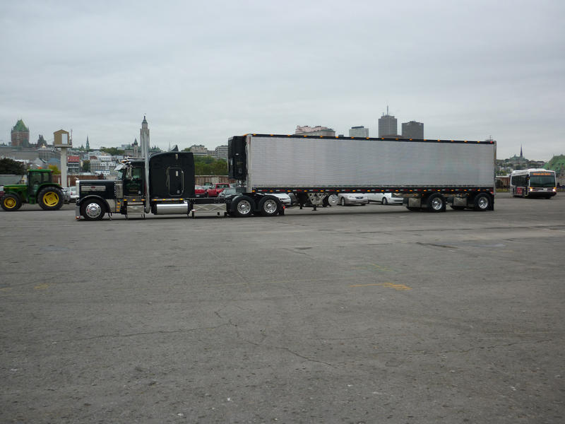 Side view of a large rig comprising a semi truck and trailer used for long distance road haulage and transport with copyspace