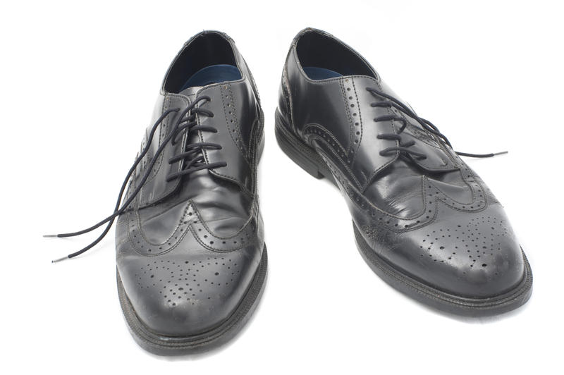 A pair of stylish black leather fashionable gents lace-up dress shoes on a white background