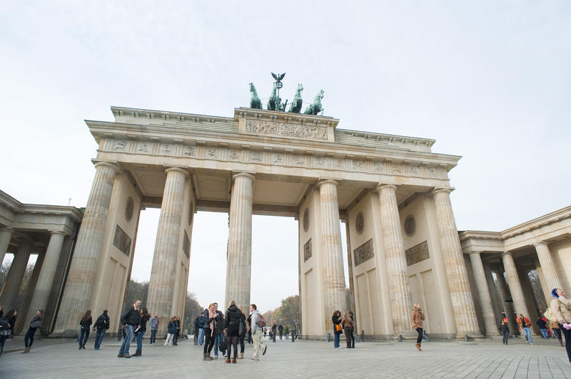 A daytime shot of The Brandenburg Gate, Berlin, with lots of tourists wandering about